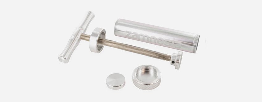Zamnesia Super Pollen Press Eine silberne Metallspritze mit Griff und Kolben.