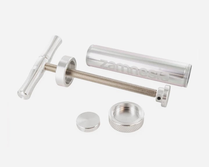 Zamnesia Super Pollen Press Eine silberne Metallspritze mit Griff und Kolben.