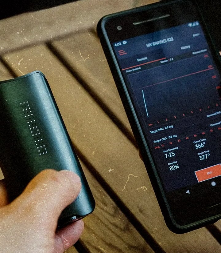 DaVinci IQ3 Vaporizer: Next-Gen-Funktionen & Überlegene Leistung PAX IQ3 Vaporizer mit App, die 80 % Akku, THC 0,5 mg und 366 °F zeigt, neben einem Telefon auf einem Holztisch.