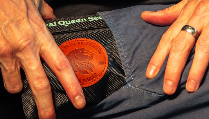 Bild von Händen, die eine geruchsdichte Cannabis-Aufbewahrungstasche in eine Tasche stecken.