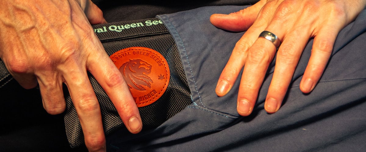 Bild von Händen, die eine geruchsdichte Cannabis-Aufbewahrungstasche in eine Tasche stecken.