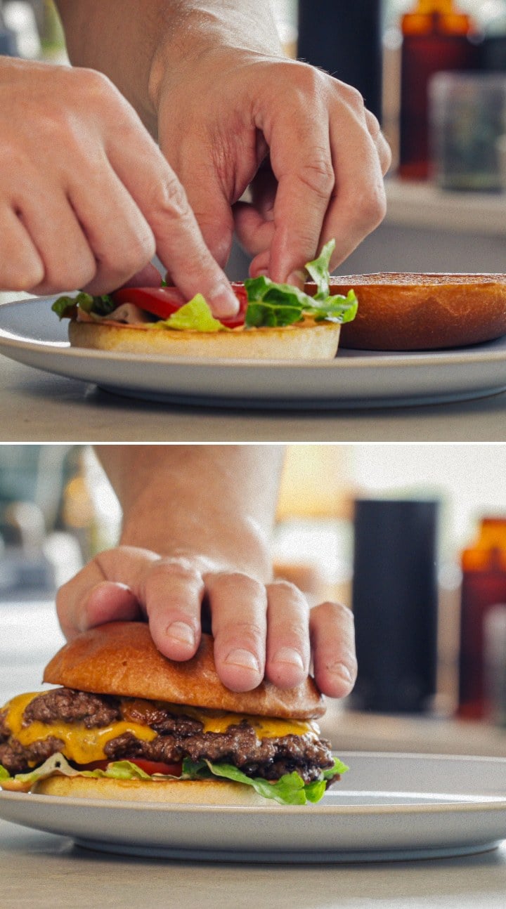 Fertiger Cannabis-Burger – Servierbereit mit infundiertem Brötchen und Cheddar Zusammenstellen und Servieren eines fertigen Cannabis-Burgers mit geschmolzenem Cheddar, Salat, Tomate und infundiertem Brötchen