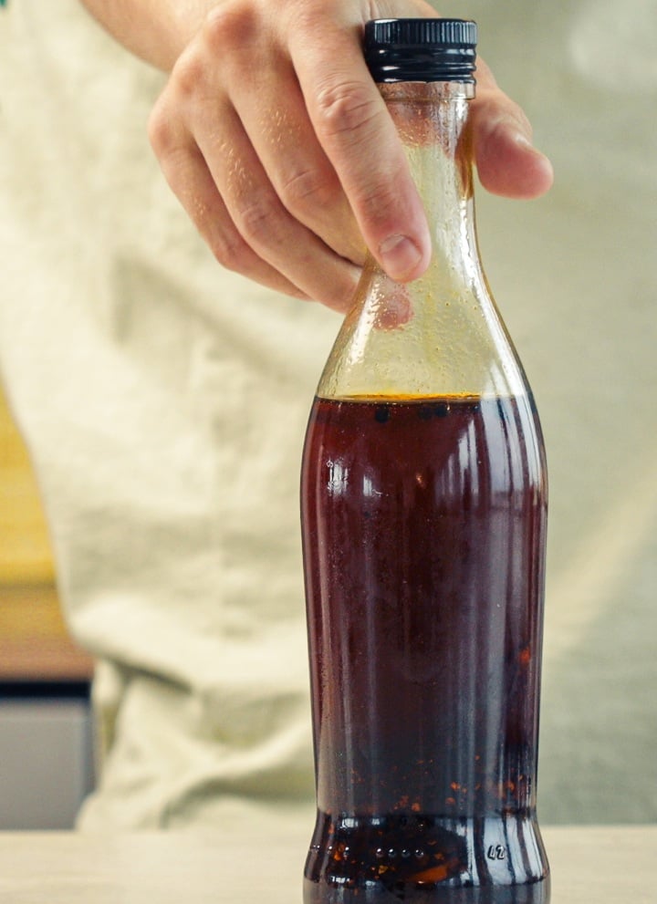 Verschlossene Glasflasche mit Chili-Cannabis-Öl zur Aufbewahrung in einer Küche