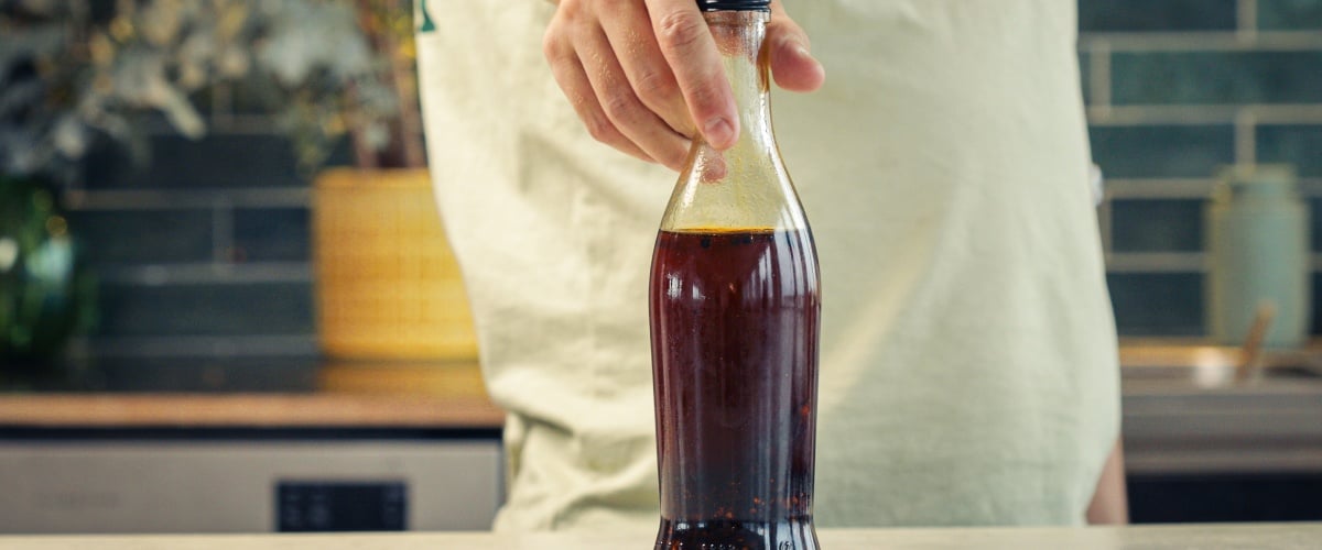 Verschlossene Glasflasche mit Chili-Cannabis-Öl zur Aufbewahrung in einer Küche