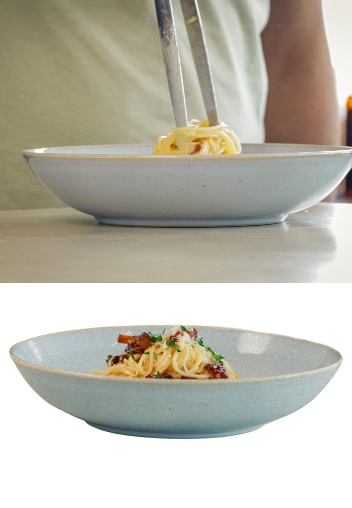 Cremige Cannabis-infundierte Spaghetti Carbonara mit Pancetta und geriebenem Käse anrichten, letzter Schritt vor dem Servieren